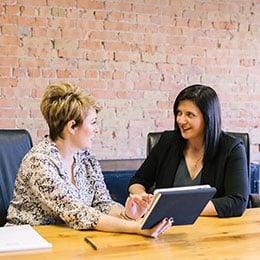 IMG: Two Business Women Talking at table