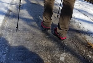 Hiker using Crampons to walk across ice covered trail in Wisconsin